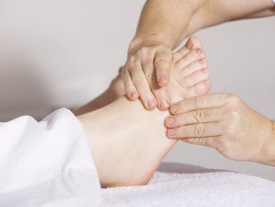 A therapist massages a patient's foot in an effort to ease pain.
